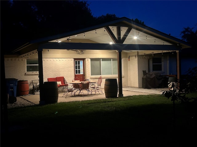12305 Sunland St, Dallas, TX 75218 - back of house at twilight with a patio area and brick siding