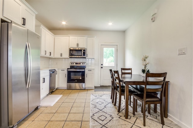 408 Peabody St, Hillsboro, TX 76645 - kitchen featuring appliances with stainless steel finishes, decorative backsplash, light countertops, white cabinets, and light tile patterned floors