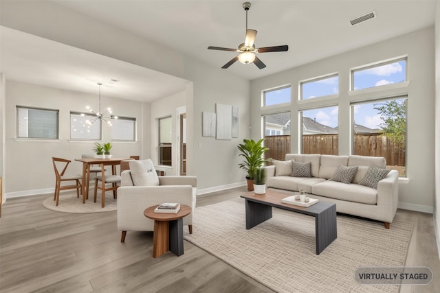 1725 Rolling Heights Ln, Fort Worth, TX 76008 - living room featuring light wood-style floors, baseboards, a chandelier, and a ceiling fan