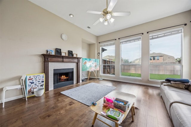 4077 Truman Dr, Frisco, TX 75034 - living area with a lit fireplace, ceiling fan, wood finished floors, and baseboards