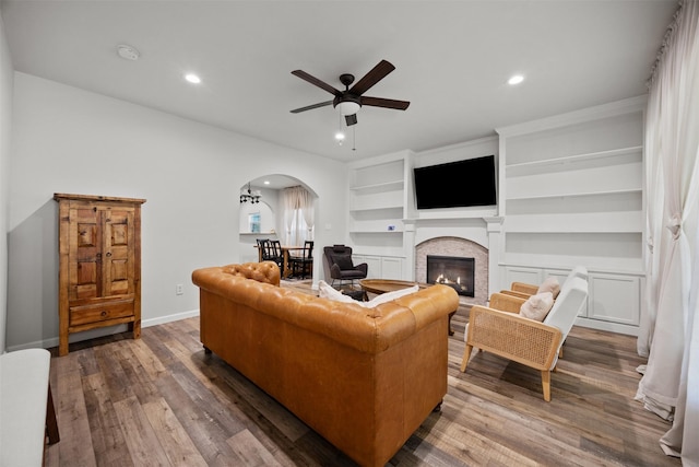 3208 Travis Ave, Fort Worth, TX 76110 - living area with arched walkways, ceiling fan, recessed lighting, wood finished floors, and a glass covered fireplace