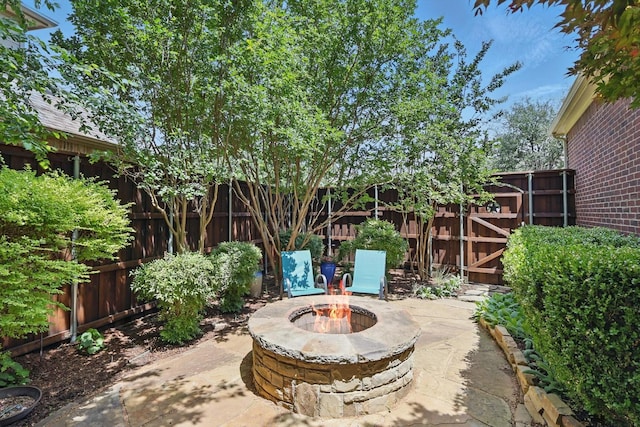 2453 Sir Lovel Ln, Lewisville, TX 75056 - fenced backyard featuring an outdoor fire pit and a patio