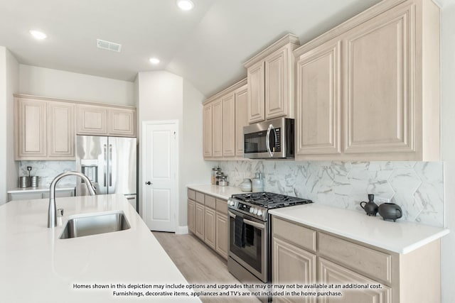 1036 Snowy Owl Dr, Alvarado, TX 76009 - kitchen with appliances with stainless steel finishes, a sink, tasteful backsplash, light countertops, and vaulted ceiling