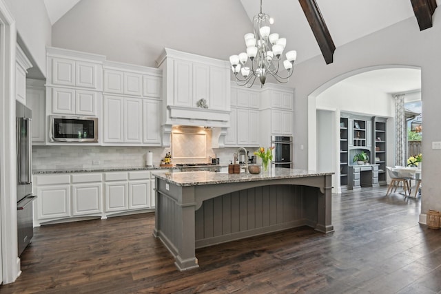 4064 Covent Garden Ln, Frisco, TX 75034 - kitchen with appliances with stainless steel finishes, high vaulted ceiling, arched walkways, white cabinetry, and tasteful backsplash