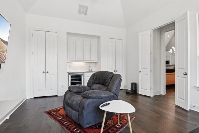 4064 Covent Garden Ln, Frisco, TX 75034 - sitting room featuring lofted ceiling, wine cooler, dark wood finished floors, bar with sink, and baseboards