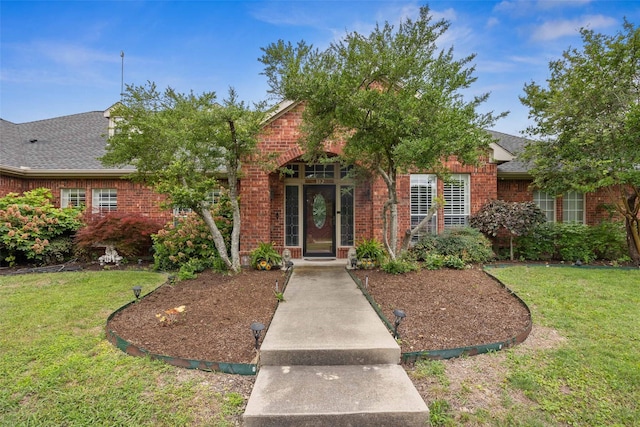 102 Dove Crk, Mckinney, TX 75071 - obstructed view of property with brick siding, a front yard, and a shingled roof
