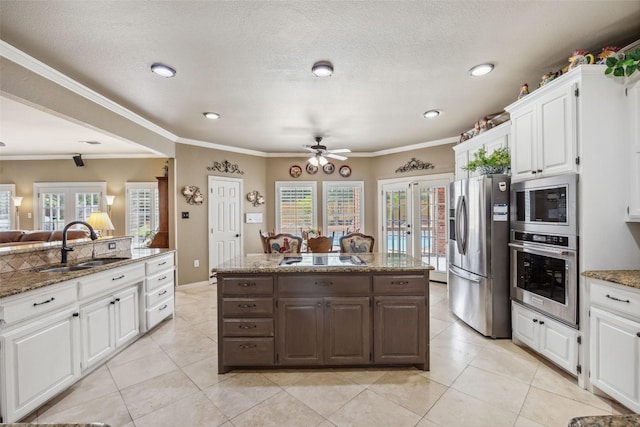 102 Dove Crk, Mckinney, TX 75071 - kitchen with appliances with stainless steel finishes, french doors, a sink, a ceiling fan, and white cabinetry