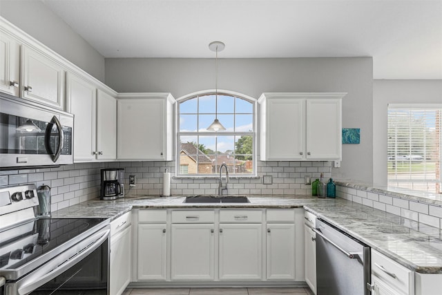 2122 Quail Ridge Dr, Weatherford, TX 76087 - kitchen with appliances with stainless steel finishes, white cabinets, tasteful backsplash, and plenty of natural light