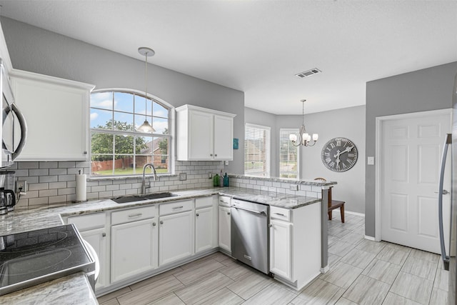 2122 Quail Ridge Dr, Weatherford, TX 76087 - kitchen featuring appliances with stainless steel finishes, a peninsula, decorative backsplash, and white cabinets