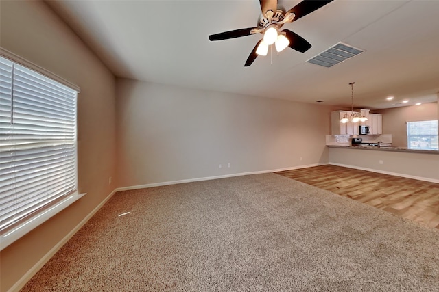 2117 Jeanine Dr, Anna, TX 75409 - unfurnished living room featuring carpet flooring, a chandelier, baseboards, and a ceiling fan