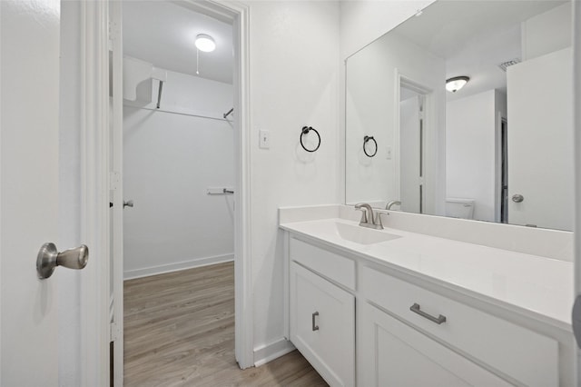 4536 Louisville Dr, Plano, TX 75093 - bathroom featuring vanity, wood finished floors, baseboards, toilet, and a spacious closet