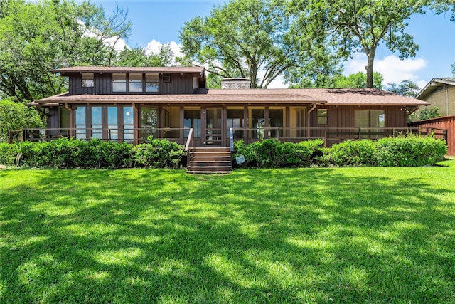 188 Enchanted Dr, Enchanted Oaks, TX 75156 - rear view of property featuring a sunroom, a chimney, a lawn, and board and batten siding
