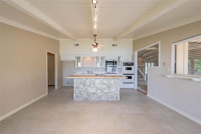 188 Enchanted Dr, Enchanted Oaks, TX 75156 - kitchen featuring stainless steel microwave, double oven, white cabinets, light countertops, and a sink