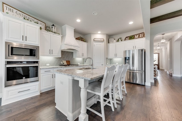 10321 Colina Dr, Fort Worth, TX 76126 - kitchen with stainless steel appliances, custom range hood, a sink, arched walkways, and decorative backsplash