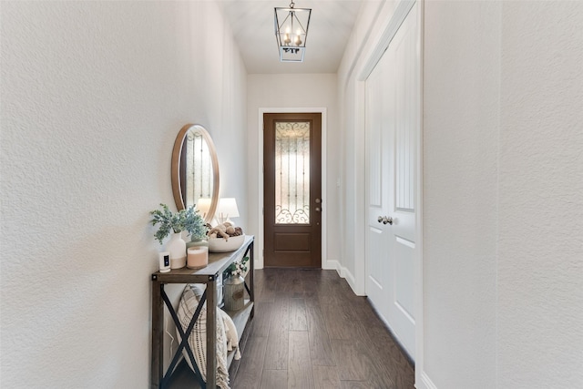 10321 Colina Dr, Fort Worth, TX 76126 - doorway featuring dark wood-type flooring, a chandelier, a textured wall, and baseboards