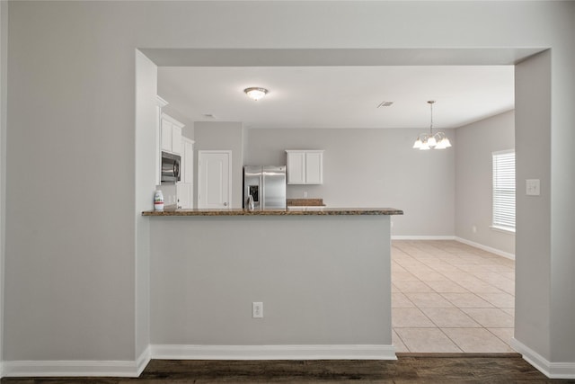 134 Kennedy Dr, Venus, TX 76084 - kitchen featuring appliances with stainless steel finishes, white cabinets, a peninsula, and dark stone countertops