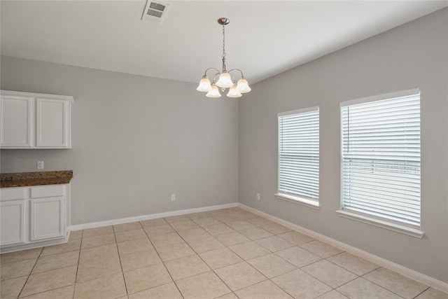 134 Kennedy Dr, Venus, TX 76084 - unfurnished dining area featuring a chandelier, baseboards, and light tile patterned floors