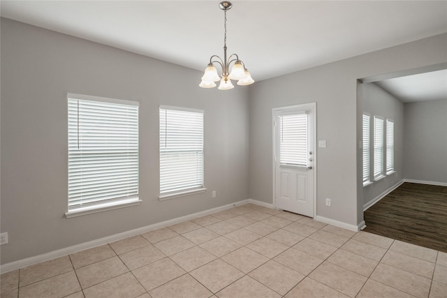 134 Kennedy Dr, Venus, TX 76084 - empty room featuring a chandelier, light tile patterned flooring, and baseboards