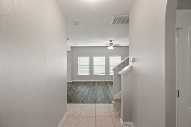 134 Kennedy Dr, Venus, TX 76084 - hallway featuring light tile patterned flooring, stairway, baseboards, and arched walkways