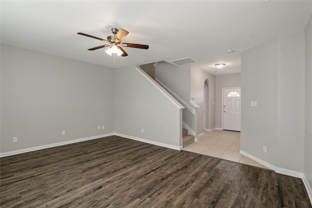 134 Kennedy Dr, Venus, TX 76084 - unfurnished room with arched walkways, stairs, wood finished floors, a ceiling fan, and baseboards