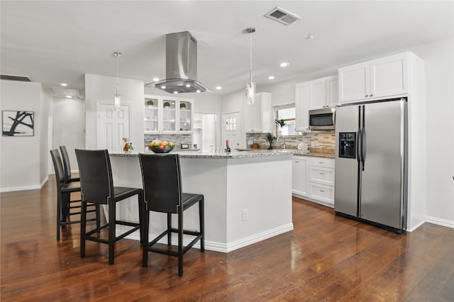 634 N Tyler St, Dallas, TX 75208 - kitchen with appliances with stainless steel finishes, island range hood, tasteful backsplash, white cabinets, and recessed lighting