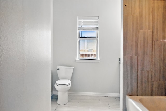 634 N Tyler St, Dallas, TX 75208 - full bath with baseboards, toilet, and a tub to relax in