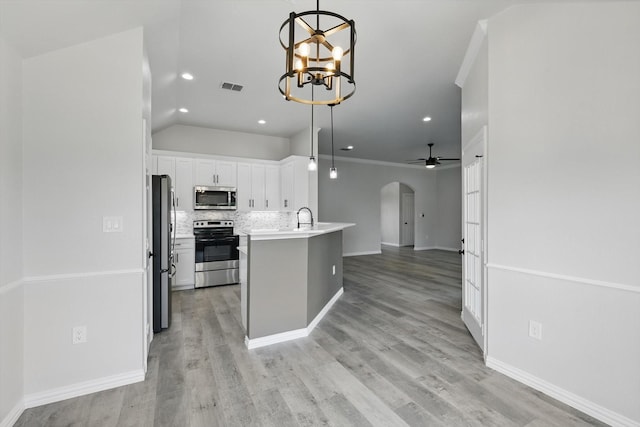 130 N Point Dr, Krum, TX 76249 - kitchen with stainless steel appliances, arched walkways, open floor plan, decorative backsplash, and white cabinetry