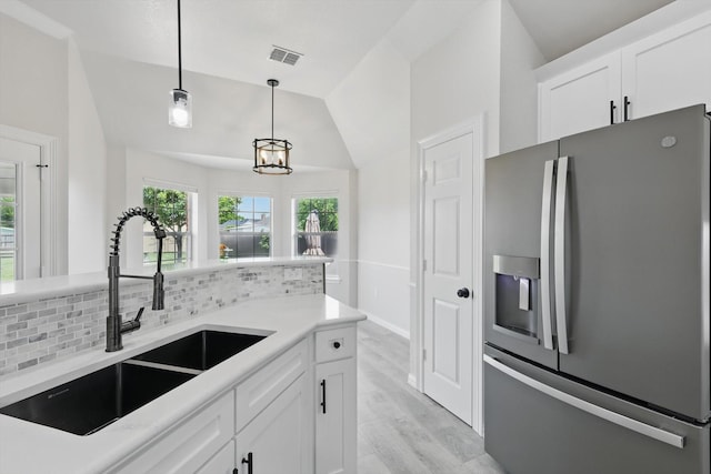 130 N Point Dr, Krum, TX 76249 - kitchen with stainless steel fridge with ice dispenser, a sink, vaulted ceiling, decorative light fixtures, and white cabinetry