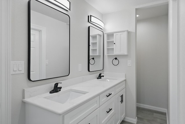 130 N Point Dr, Krum, TX 76249 - bathroom featuring double vanity, baseboards, and wood finished floors
