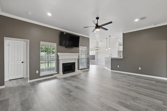130 N Point Dr, Krum, TX 76249 - unfurnished living room with a ceiling fan, crown molding, a fireplace with raised hearth, baseboards, and wood finished floors