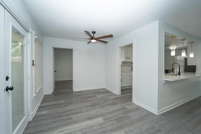 704 Vine St, Euless, TX 76040 - unfurnished living room with a ceiling fan, a sink, wood finished floors, and baseboards