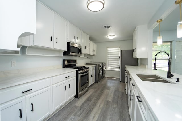 704 Vine St, Euless, TX 76040 - kitchen featuring stainless steel appliances, a sink, white cabinets, and dark wood-type flooring