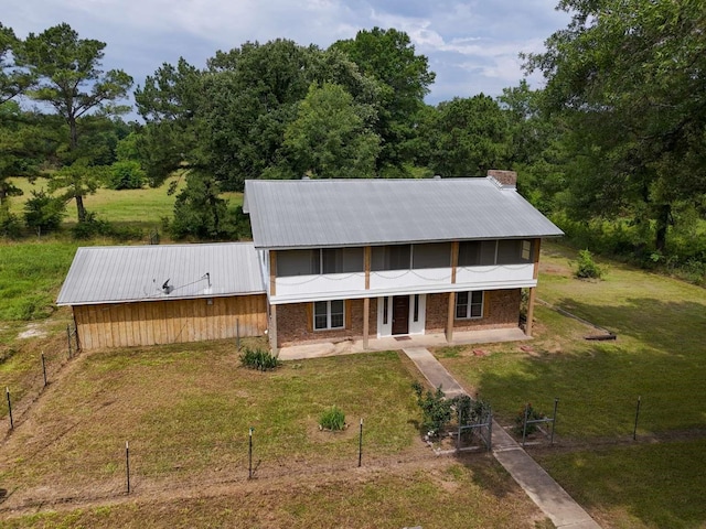 3474 County Road 1412, Bogata, TX 75417 - view of front facade with covered porch, metal roof, brick siding, and a chimney