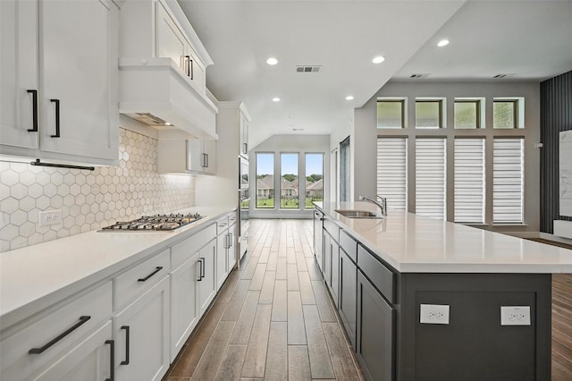 1419 Misty Pasture Way, Mansfield, TX 76063 - kitchen featuring wood finished floors, light countertops, tasteful backsplash, a kitchen island with sink, and white cabinets