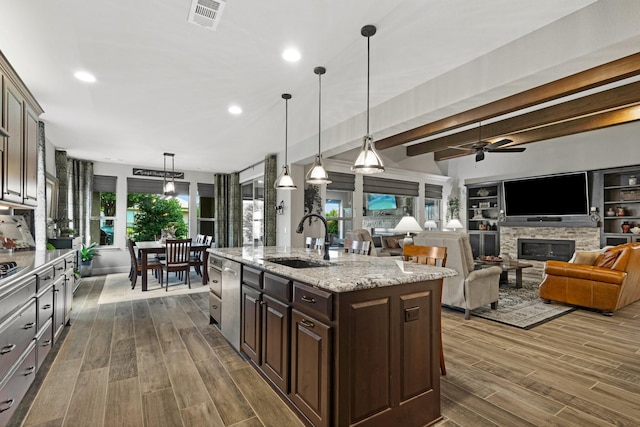 8217 American Way, Denton, TX 76207 - kitchen featuring a sink, dark wood finished floors, dark brown cabinets, a stone fireplace, and beam ceiling