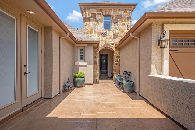8217 American Way, Denton, TX 76207 - property entrance featuring stone siding, stucco siding, a patio, and a shingled roof