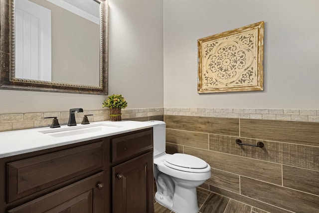 8217 American Way, Denton, TX 76207 - bathroom featuring toilet, vanity, tile walls, ornamental molding, and a wainscoted wall