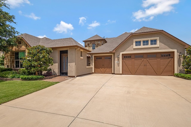 8217 American Way, Denton, TX 76207 - view of front of home featuring stucco siding, a garage, driveway, and a front lawn