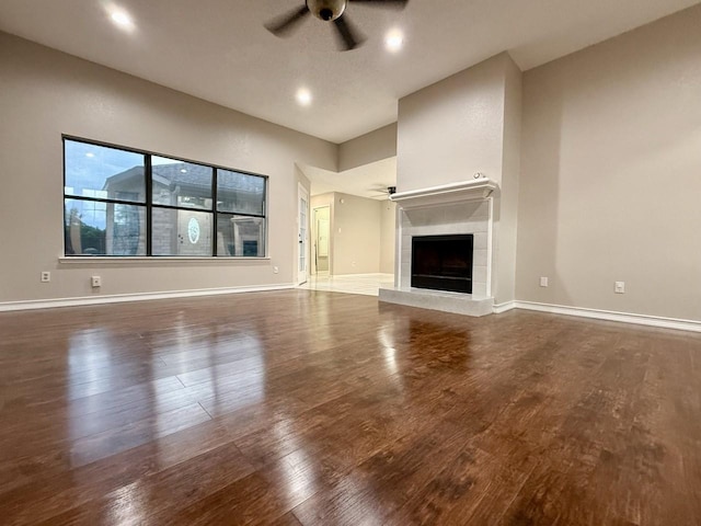1001 Schrade Trl, Mesquite, TX 75181 - unfurnished living room featuring ceiling fan, wood finished floors, a tiled fireplace, baseboards, and recessed lighting