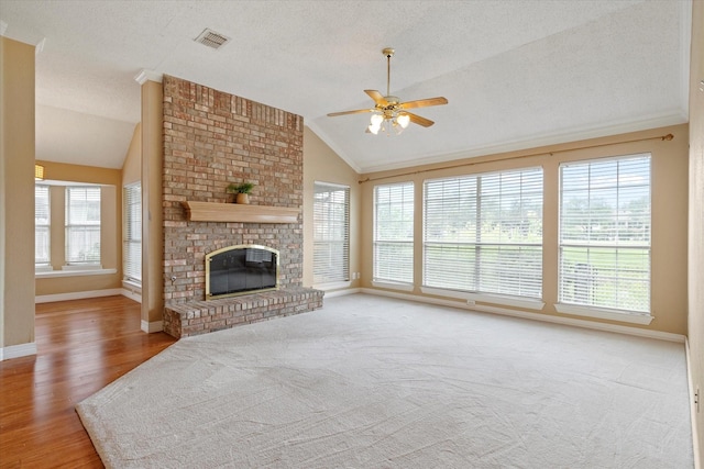 11200 Williamsburg Ln, Frisco, TX 75035 - unfurnished living room featuring vaulted ceiling, a ceiling fan, baseboards, a brick fireplace, and a textured ceiling