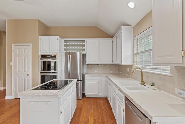 11200 Williamsburg Ln, Frisco, TX 75035 - kitchen featuring stainless steel appliances, open shelves, light wood-style floors, white cabinetry, and vaulted ceiling