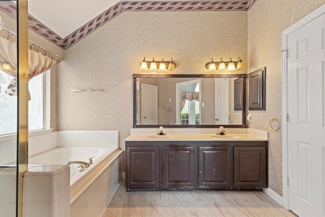 11200 Williamsburg Ln, Frisco, TX 75035 - bathroom with wallpapered walls, plenty of natural light, double vanity, a bath, and vaulted ceiling