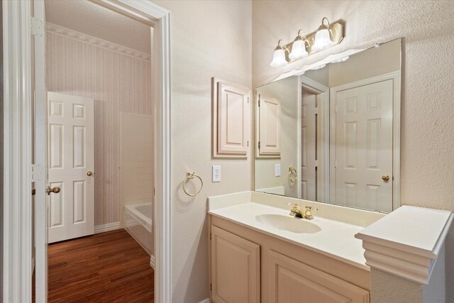 11200 Williamsburg Ln, Frisco, TX 75035 - full bath with wood finished floors, vanity, and a textured wall