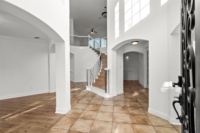 1228 Copano Dr, Allen, TX 75013 - foyer entrance featuring a towering ceiling, arched walkways, a ceiling fan, stairs, and baseboards