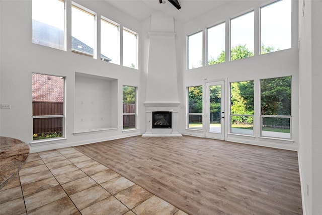 1228 Copano Dr, Allen, TX 75013 - unfurnished living room featuring a towering ceiling, a fireplace, and wood finished floors