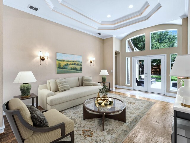 511 Cloud View Ct, Prosper, TX 75078 - unfurnished living room featuring wood finished floors, crown molding, a tray ceiling, arched walkways, and french doors