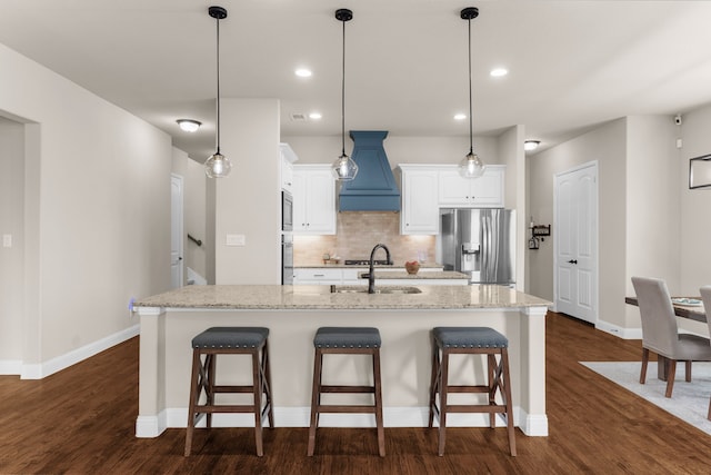 2402 Wilson Dr, Anna, TX 75409 - kitchen featuring appliances with stainless steel finishes, custom range hood, white cabinets, a kitchen breakfast bar, and backsplash