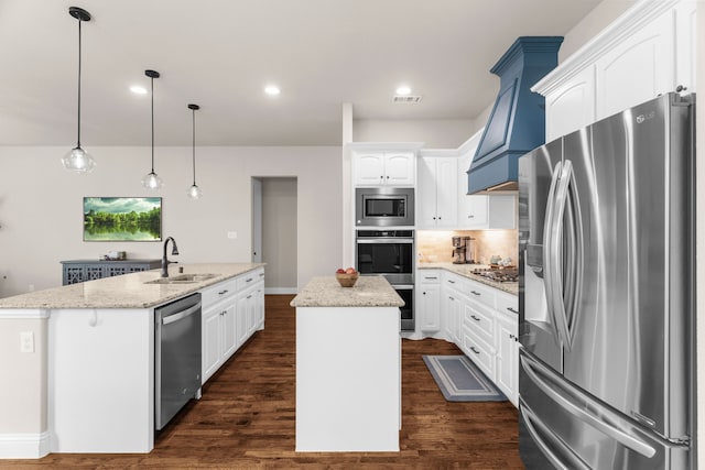 2402 Wilson Dr, Anna, TX 75409 - kitchen featuring appliances with stainless steel finishes, an island with sink, custom exhaust hood, white cabinets, and recessed lighting