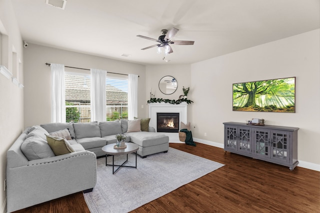 2402 Wilson Dr, Anna, TX 75409 - living area with dark wood finished floors, a glass covered fireplace, and ceiling fan