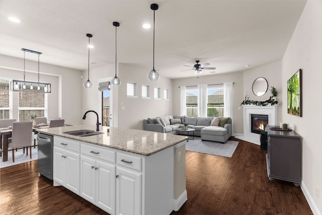 2402 Wilson Dr, Anna, TX 75409 - kitchen featuring a ceiling fan, a glass covered fireplace, dishwasher, dark wood finished floors, and white cabinetry